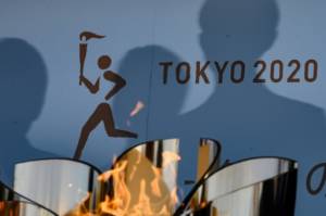 Fans, but no cheering, for delayed Olympic torch relay.jpg