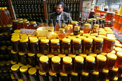 A honey vendor waits for customers market in Chamkanni on the outskirts of Peshawar
