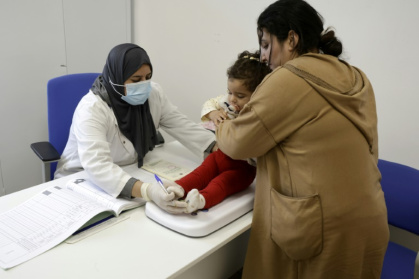 A nurse examines a child before giving her a doze of measles vaccine at a hospital in the Moroccan coastal city of Temara on February 27, 2025.