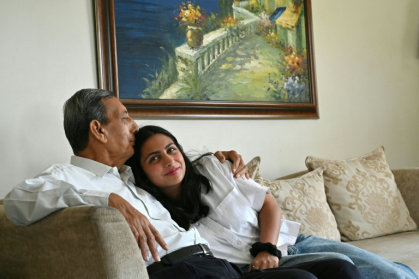 In this photograph taken on February 28, 2025, Kersi Umrigar (L), a 76-year-old, embraces his granddaughter Elisha Amra at his residence in a Karachi enclave reserved for Zoroastrians