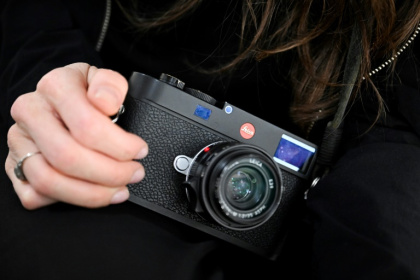 German photographer Franziska Stuenkel holds an M11 Leica camera during an interview with AFP in Frankfurt