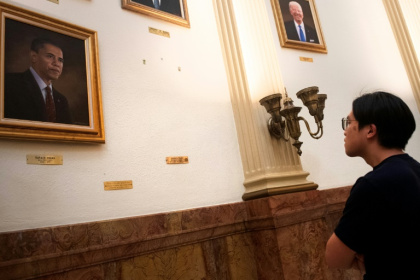 A tourist looks at the empty space where a portrait of US President Donald Trump once hung in the Presidential Portrait Gallery at the Colorado Capitol in Denver