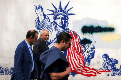 Iranian walk past a mural on the walls of the former US embassy building in Tehran, dubbed the "Den of Spies" since the Islamic revolution of 1979.