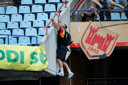 An Esperance supporter clings to a railing at a Pretoria stadium during crowd violence after a CAF Champions League match against Mamelodi Sundowns on April 1.
