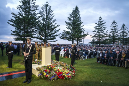 Australians and New Zealanders gathered just before dawn to observe solemn Anzac Day ceremonies