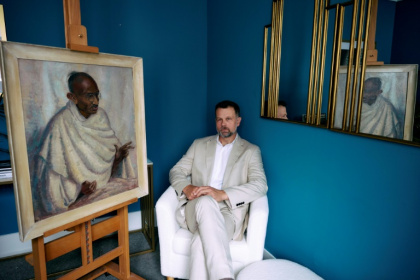 Caspar Leighton with a portrait by his great-aunt of Indian independence leader Mahatma Gandhi - BENJAMIN CREMEL (AFP)