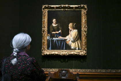 A woman views 'Mistress and Maid' by Johannes Vermeer at the Frick Collection in New York - ANGELA WEISS (AFP)