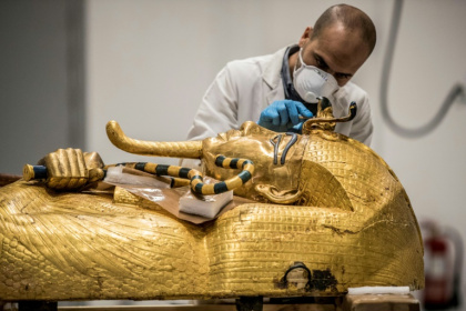 An archaeologist performs restorations on the sarcophagus of Pharaoh Tutankhamun in the restoration lab of the Grand Egyptian Museum in 2020 - Khaled DESOUKI (AFP)