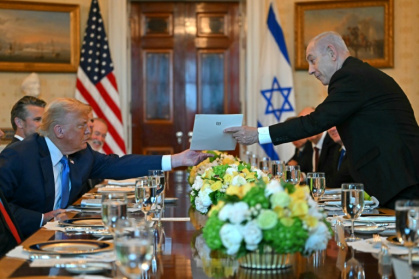 Israeli Prime Minister Benjamin Netanyahu hands over a letter to US President Donald Trump as they meet at the Blue Room of the White House - ANDREW CABALLERO-REYNOLDS (AFP)