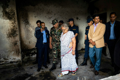 Nepal's interim leader Sushila Karki (C, inspecting a torched police station) vowed to follow protesters' demands to 'end corruption' in the Himalayan nation - PRABIN RANABHAT (AFP)