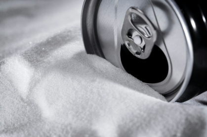 A soft drink can sitting on a bed of sugar. The WHO wants taxes raised on sugary drinks - JOEL SAGET (AFP)