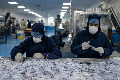 Workers assemble and package disposable syringes at the Milli Shifa Pharmaceutical factory on the outskirts of Kabul - Wakil KOHSAR (AFP)