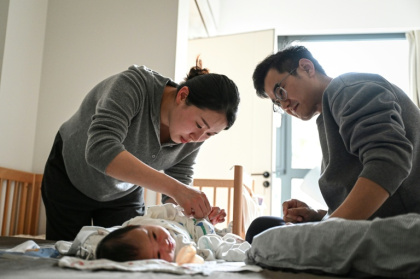 Wang Yifan (left) says paediatrician avatars helped answer questions about her baby, reducing trips to hospital - Jade GAO (AFP)
