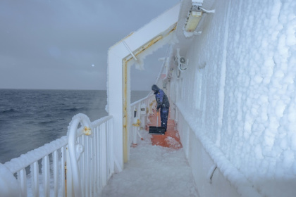 Voyage to the north: a crew member clears ice from the deck of Greenland's Sarfaq Ittuk ferry - Florent VERGNES (AFP)