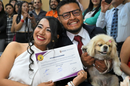 Diana Tupiza and Andres Alquinga pose with their dog Luna, who served as a "witness" at their civil wedding and stamped the marriage certificate with her paw print - Rodrigo BUENDIA (AFP)