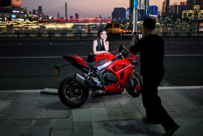 Bikers in China's Chongqing offer packages of choreographed photos and videos, cruising past the city's landmarks - WANG Zhao (AFP)