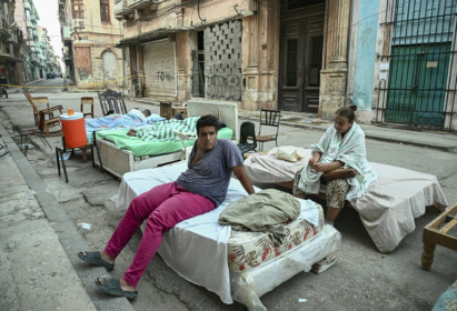 Sleeping out in the stifling summer heat leaves residents of a partially collapsed building exhausted - YAMIL LAGE (AFP)