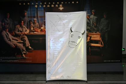 A hand-drawn poster advertising the film "Niu Lai", which translates to "Here Comes the Cow", is seen at a cinema in Beijing - Pedro PARDO (AFP)